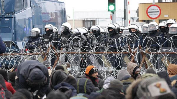 Policiais da Polônia do lado polonês da fronteira com Belarus, com migrantes do outro lado, em preparação para cruzar a fronteira no ponto de cruzamento de Bruzgi-Kuznica Bialostocka, Polônia, 15 de novembro de 2021 - Sputnik Brasil