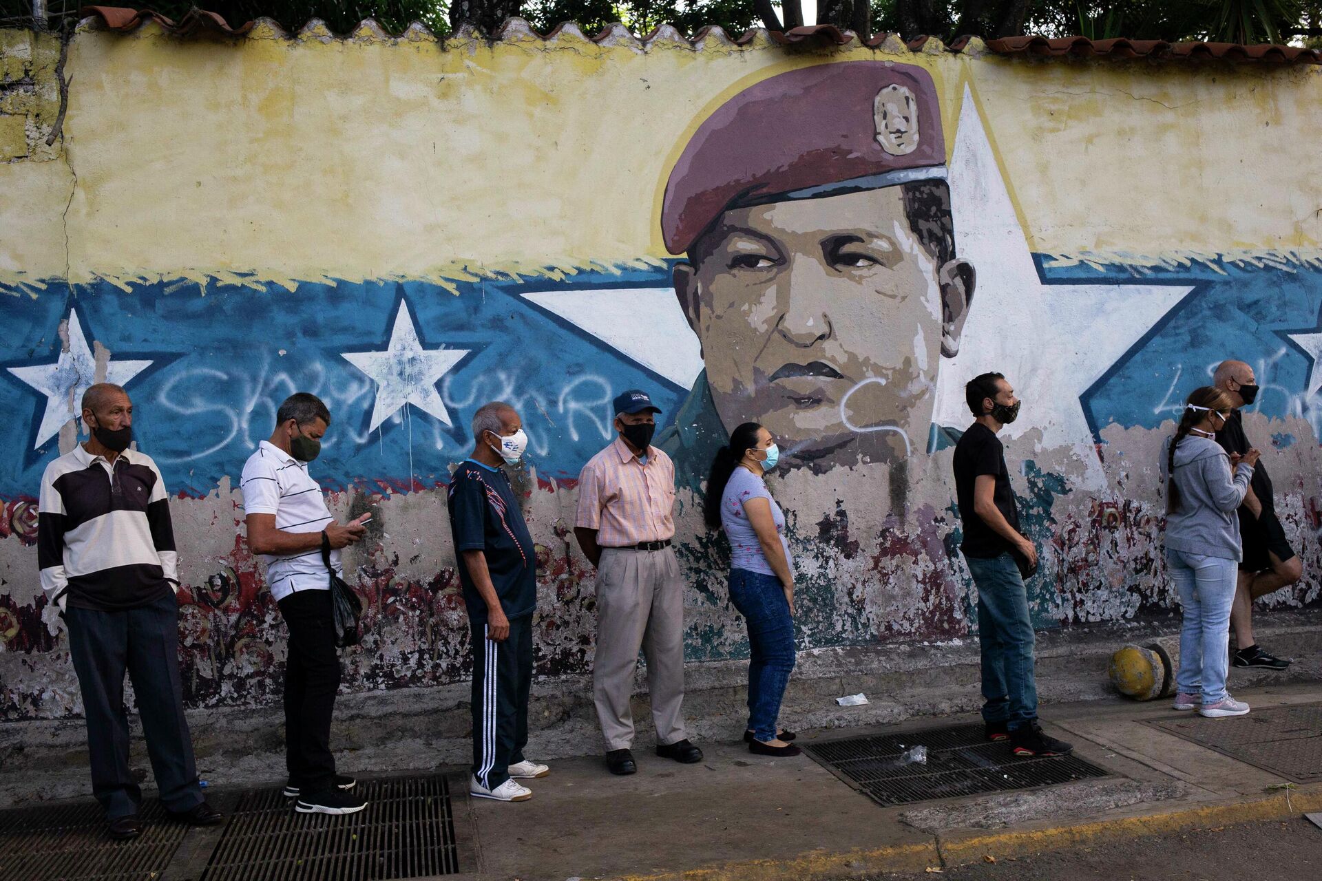 Venezuelanos na fila para votação em Caracas, perto de mural retratando o ex-presidente venezuelano, Hugo Chavez, durante eleições regionais no país, 21 de novembro de 2021 - Sputnik Brasil, 1920, 22.11.2021