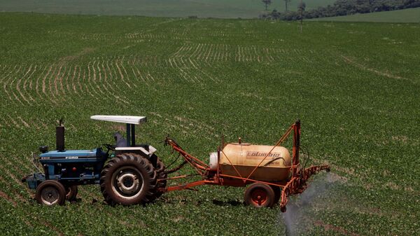 Trator joga fertilizantes em plantação de soja (foto de arquivo) - Sputnik Brasil
