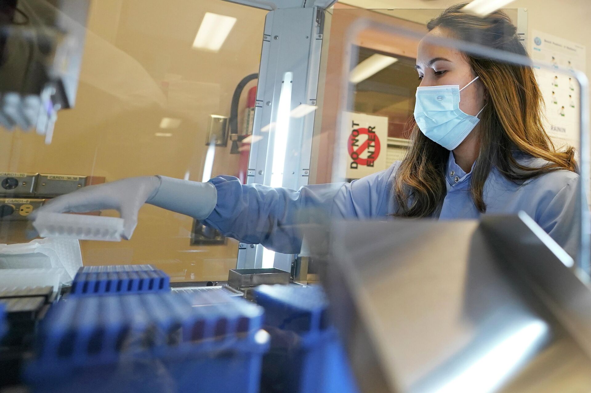 Microbiologista da equipe de COVID-19 do Laboratório de Saúde Pública do Departamento de Saúde do Estado de Washington, nos EUA, carrega amostras com resultado positivo para a doença em máquina que prepara para sequenciamento automático do genoma, no dia 7 de dezembro de 2021 - Sputnik Brasil, 1920, 14.12.2021