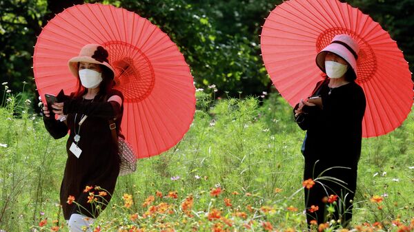 Japonesas com máscaras de proteção em Tóquio, 21 de setembro de 2021 - Sputnik Brasil