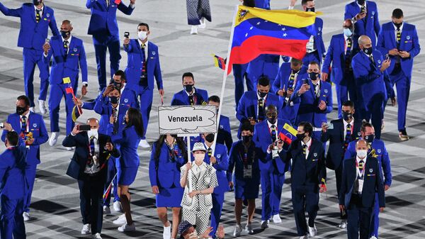 A porta-bandeira da Venezuela Karen Leon e o porta-bandeira da Venezuela Antonio Jose Diaz Fernandez lideram a delegação durante a cerimônia de abertura dos Jogos Olímpicos de Tóquio 2020, no Estádio Olímpico, em Tóquio, em 23 de julho de 2021 - Sputnik Brasil