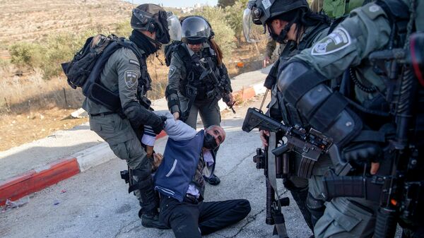 Tropas israelenses detêm homem palestino depois que colonos judeus impediram que crianças palestinas entrassem em uma escola no vilarejo de al-Lubban al-Sharqiya, perto da cidade de Nablus, na Cisjordânia, em 28 de novembro de 2021. - Sputnik Brasil