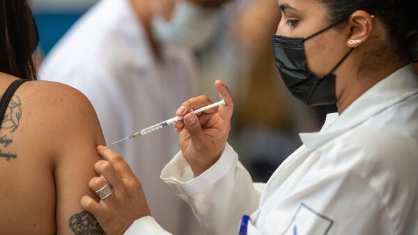 Em São Paulo, uma agente de saúde aplica uma dose de vacina contra a COVID-19, em 16 de novembro de 2021 - Sputnik Brasil