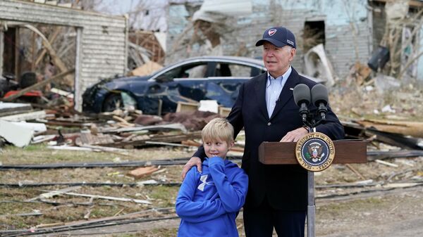 Em Dawson Springs, o presidente norte-americano, Joe Biden, discursa ao lado de uma criança sobre os danos causados por tornados no estado de Kentucky, em 15 de dezembro de 2021 - Sputnik Brasil