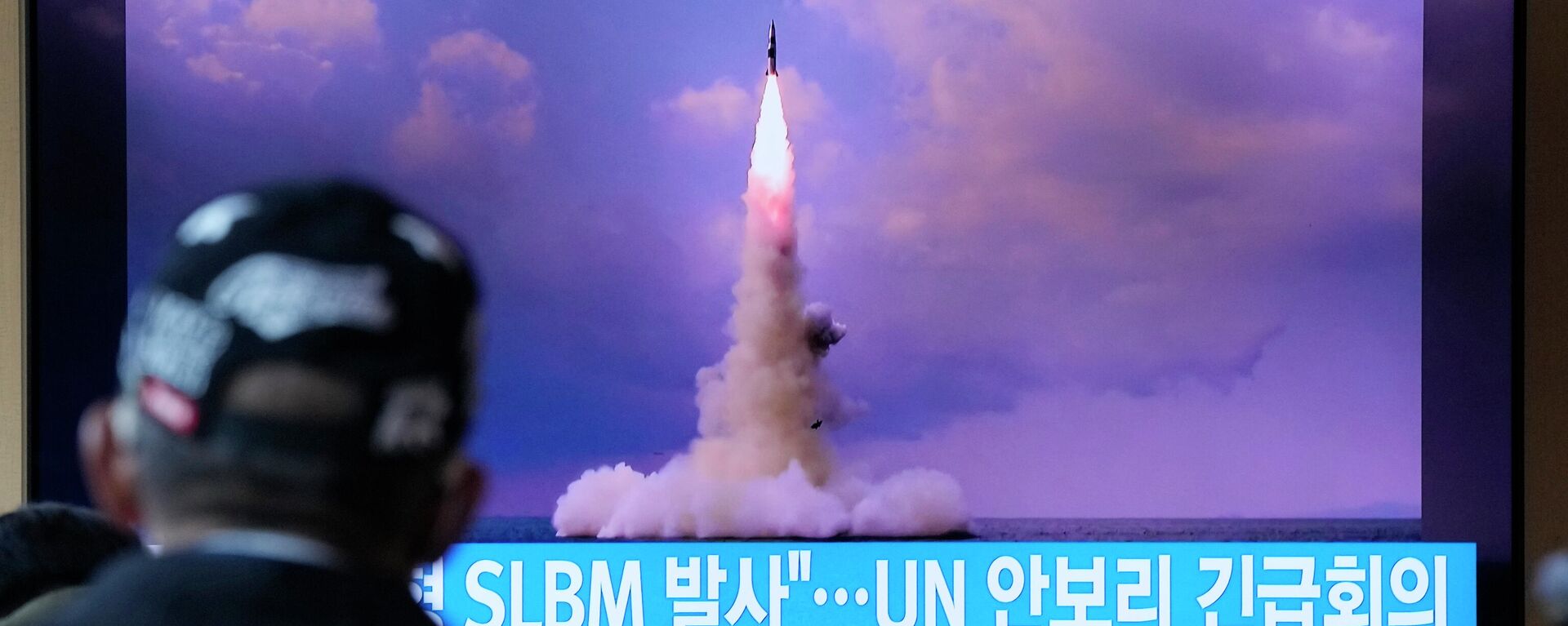 Um homem assiste a uma TV que mostra a imagem do míssil balístico da Coreia do Norte lançado de um submarino durante um programa de notícias na Estação Ferroviária de Seul, na Coreia do Sul, quarta-feira, 20 de outubro de 2021 - Sputnik Brasil, 1920, 28.01.2022
