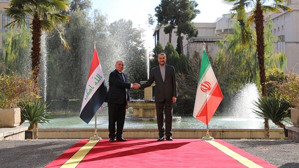 O ministro das Relações Exteriores do Irã, Hossein Amir-Abdollahian, cumprimentando seu homólogo iraquiano Fuad Hussein na capital Teerã em 23 de dezembro de 2021 - Sputnik Brasil
