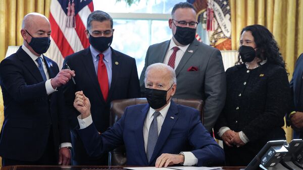 O presidente dos Estados Unidos, Joe Biden, entrega uma caneta ao secretário de Segurança Interna, Alejandro Mayorkas, após assinar uma ordem executiva com o objetivo de reduzir a burocracia em torno dos serviços públicos para o público, 13 de dezembro de 2021 - Sputnik Brasil