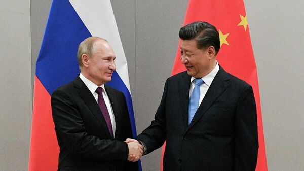 O presidente russo, Vladimir Putin, aperta a mão do presidente chinês, Xi Jinping, durante reunião paralela a uma cúpula do BRICS, em Brasília, no Brasil, em 13 de novembro de 2019 - Sputnik Brasil