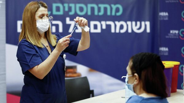 Uma enfermeira se prepara para dar quarta dose da vacina contra a doença coronavírus depois que o Ministério da Saúde aprovou um segundo reforço para imunocomprometidos, no Sheba Medical Center em Ramat Gan, Israel, 31 de dezembro de 2021 - Sputnik Brasil