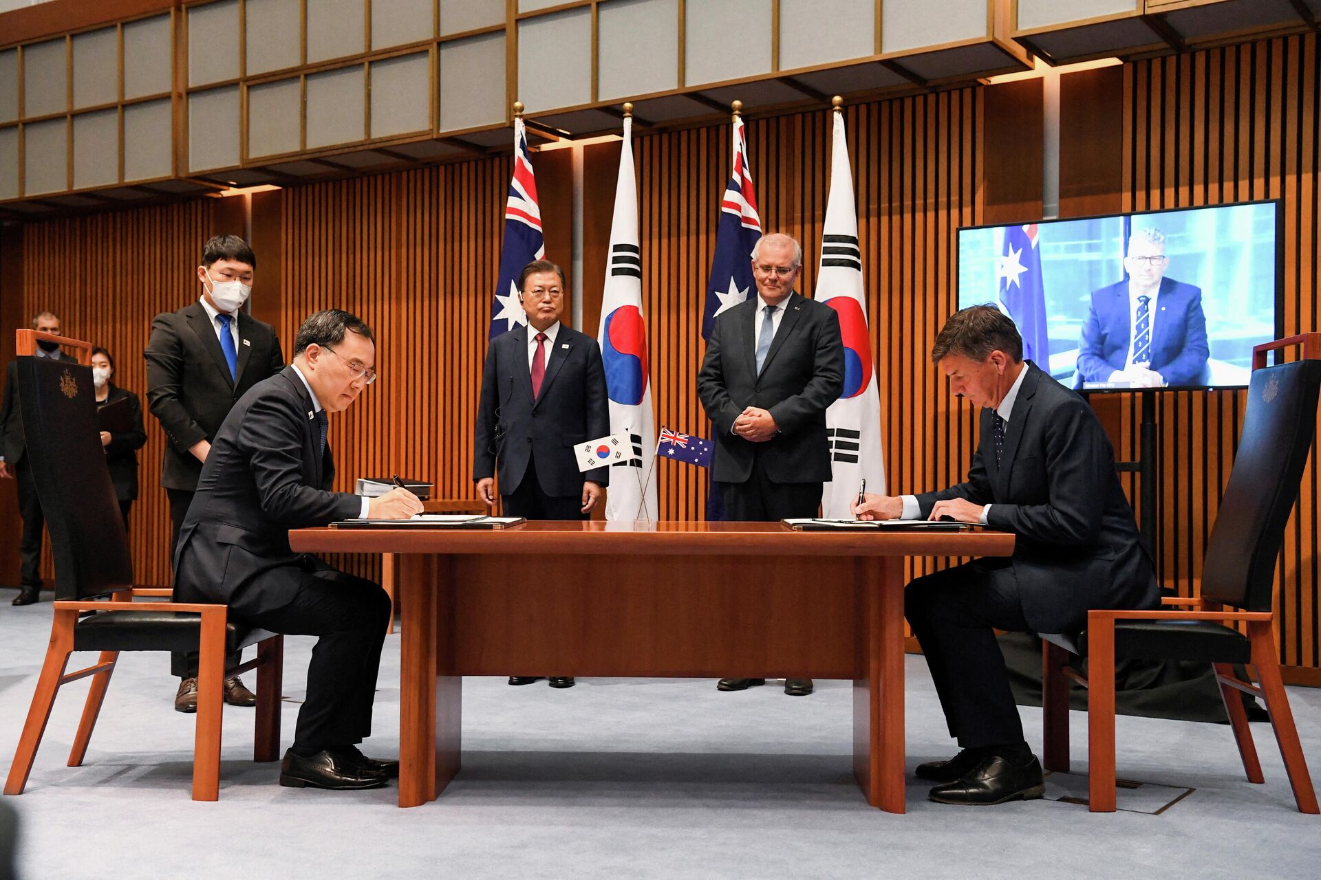 O primeiro-ministro australiano, Scott Morrison, e o presidente sul-coreano, Moon Jae-in, testemunham o ministro do Comércio sul-coreano, Yeo Han-koo, e o ministro australiano de Energia, Angus Taylor, durante cerimônia de assinatura no Parlamento, Camberra, Austrália, 13 de dezembro de 2021 - Sputnik Brasil, 1920, 04.01.2022