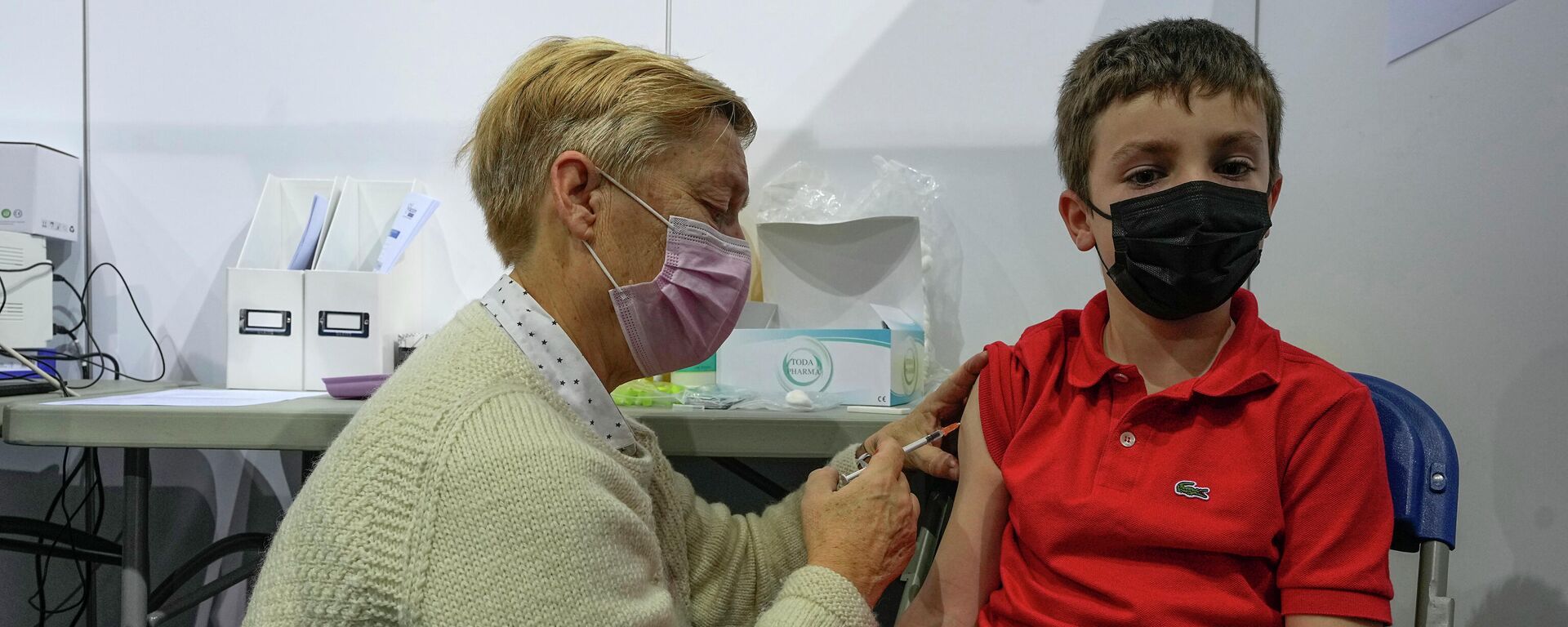 Uma profissional da saúde administra uma dose da vacina Pfizer contra a COVID-19 em uma criança de oito anos, em Saint-Quentin-en-Yvelines, a oeste de Paris, na França, no dia 22 de dezembro de 2021 - Sputnik Brasil, 1920, 04.01.2022
