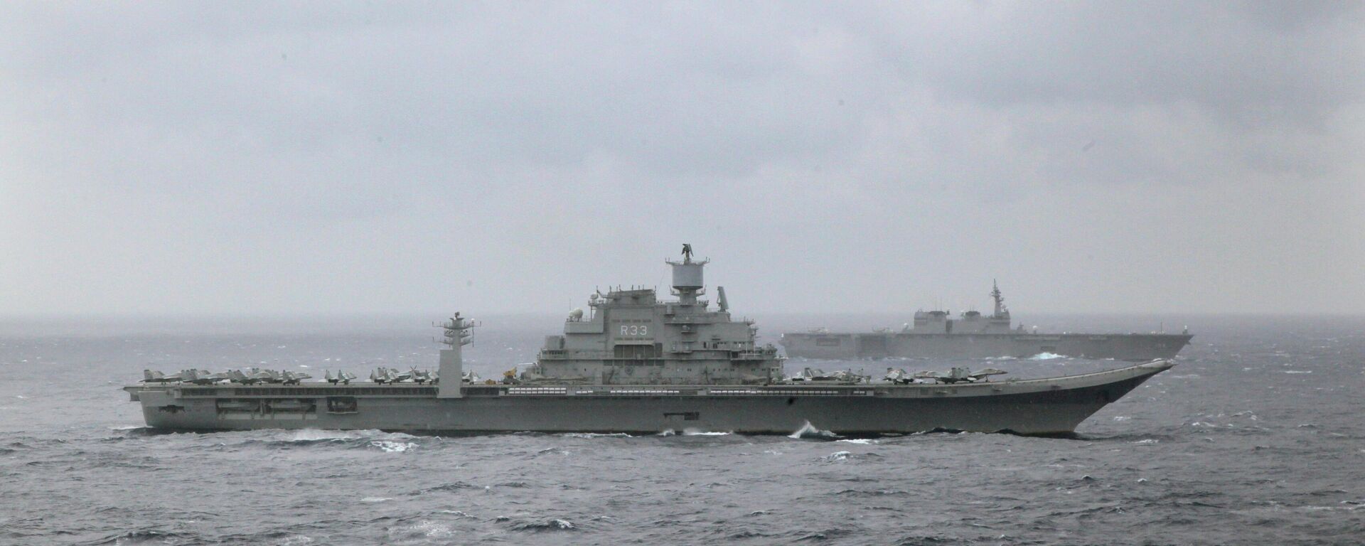 IND Vikramaditya, porta-aviões da Índia, no plano de frente, e o Izumo, porta-helicópteros do Japão, no plano de fundo, durante exercícios de guerra Malabar 2017 na Baía de Bengal em 17 de julho de 2017 - Sputnik Brasil, 1920, 09.01.2022