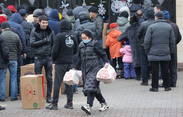 Mulher carrega sacos de plástico junto de loja após protestos em massa violentos contra a subida dos preços do combustível, Almaty, Cazaquistão, 8 de janeiro de 2022 - Sputnik Brasil