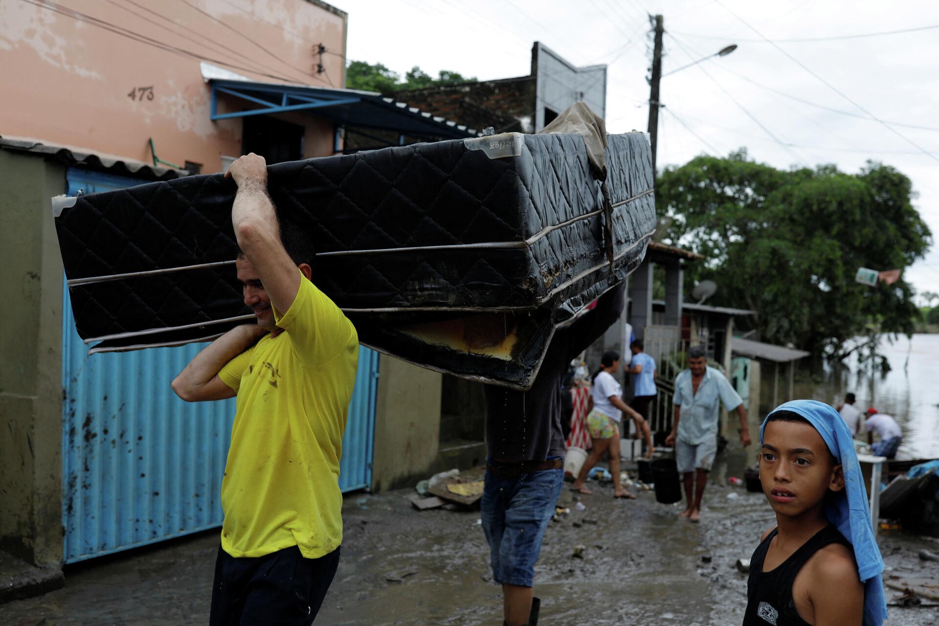 Em Itabuna, no estado brasileiro da Bahia, José Eldes carrega a cama de seu irmão após inundações na região, em 27 de dezembro de 2021 - Sputnik Brasil, 1920, 12.01.2022