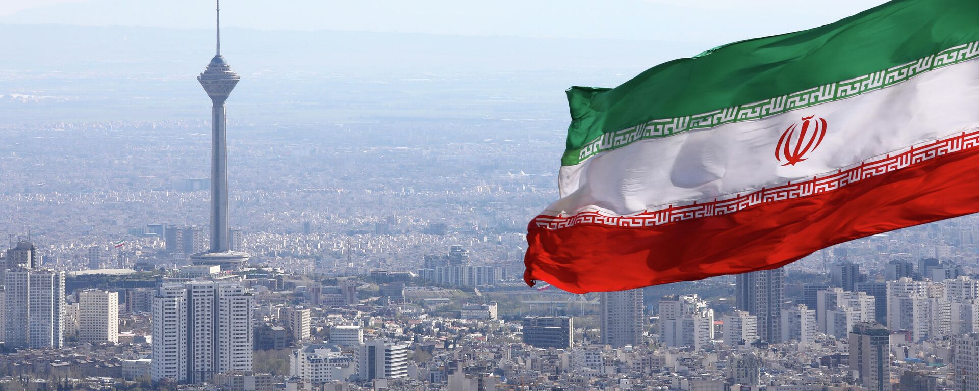 A bandeira nacional do Irã acena como a torre de telecomunicações Milad e a bandeira nacional do buildinIran acena quando os togs de telecomunicações Milad são vistos em Teerã, Irã, terça-feira, 31 de março de 2020 - Sputnik Brasil, 1920, 01.02.2023