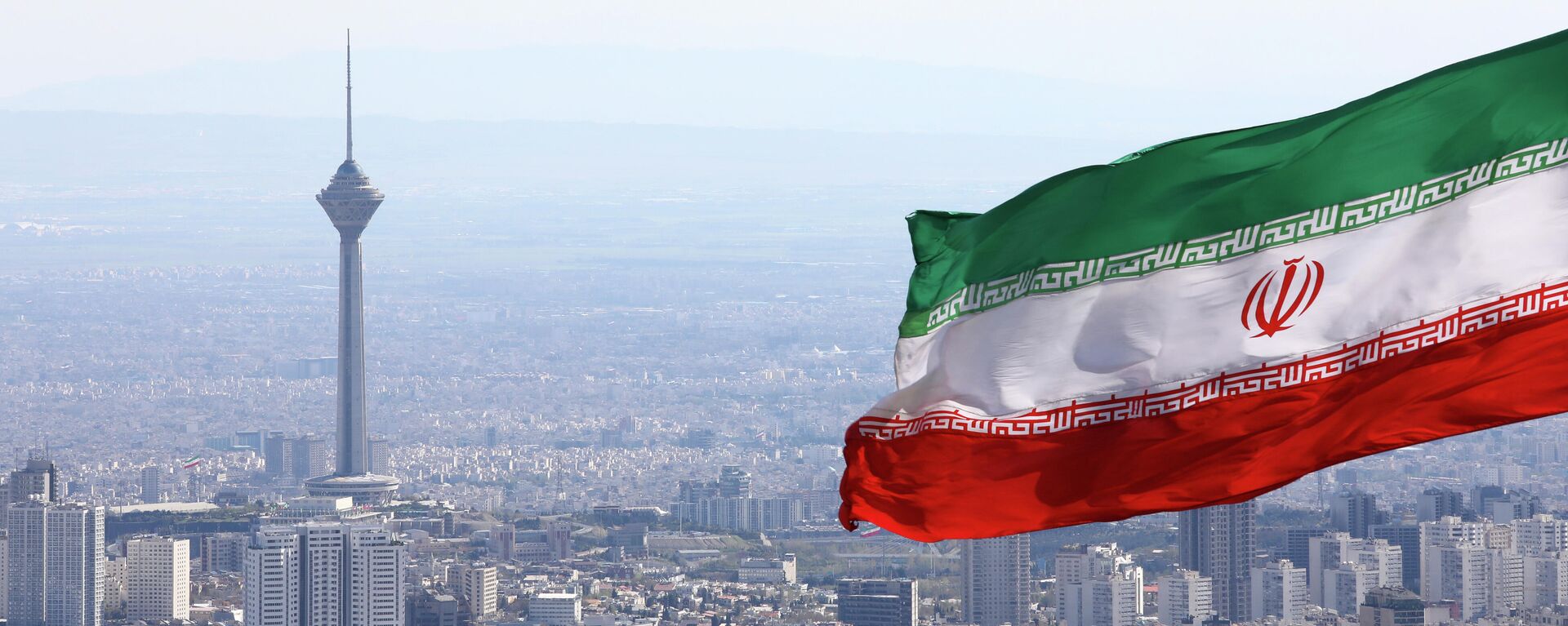 A bandeira nacional do Irã acena como a torre de telecomunicações Milad e a bandeira nacional do buildinIran acena quando os togs de telecomunicações Milad são vistos em Teerã, Irã, terça-feira, 31 de março de 2020 - Sputnik Brasil, 1920, 31.01.2023