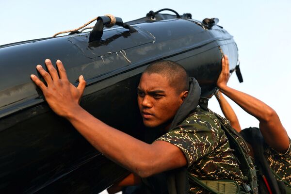 Ou Zhi-Xuan, 25, ajuda a carregar um barco de borracha para fora do mar durante a última semana do programa para se tornar membro da ARP da Marinha de Taiwan, na base naval de Zuoying, Kaohsiung, sul de Taiwan, 17 de dezembro de 2021. - Sputnik Brasil