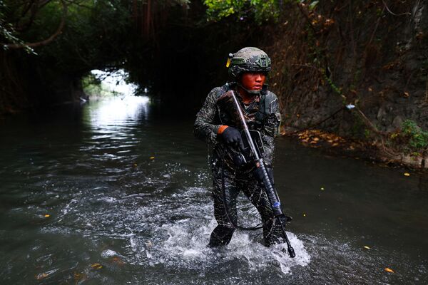 Recruta da ARP vestido com camuflagem percorre água contaminada por esgoto durante a última semana do programa intensivo para se tornar membro da ARP da Marinha de Taiwan, na base naval de Zuoying, Kaohsiung, sul de Taiwan, 21 de dezembro de 2021. - Sputnik Brasil