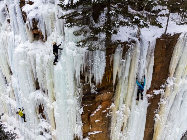 Foto aérea mostra praticantes escalando uma montanha coberta de gelo durante uma competição de escalada no Robinson Ice Park, EUA. - Sputnik Brasil