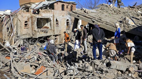 Iemenitas avaliam dados após ataques aéreos noturnos feitos pela coalizão árabe contra Sanaa, 18 de janeiro de 2022. - Sputnik Brasil