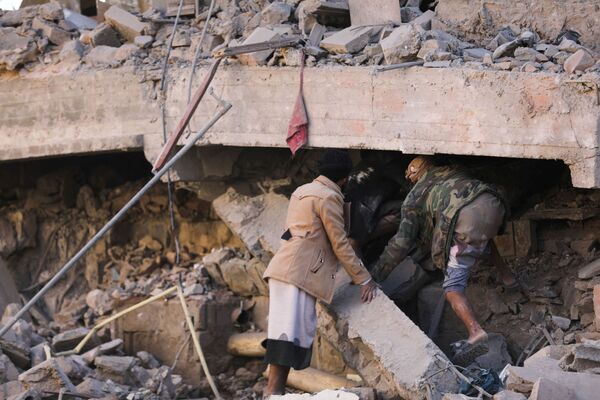 Pessoas buscam sobreviventes sob o telhado colapsado de uma casa atingida pelos ataques aéreos em Sanaa, Iêmen, 18 de janeiro de 2022. - Sputnik Brasil
