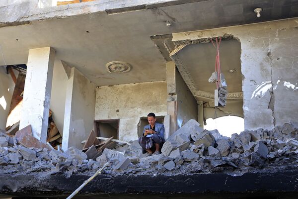 Homem em prédio danificado em resultado dos ataques aéreos árabes contra Sanaa, 18 de janeiro de 2022. - Sputnik Brasil
