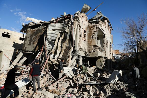Equipes de resgate removem escombros no local destruído na sequência dos bombardeios árabes contra Sanaa, capital iemenita, 18 de janeiro de 2022. - Sputnik Brasil
