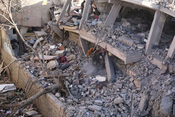 Equipes de resgate removem escombros no local destruído na sequência dos bombardeios árabes contra Sanaa, capital iemenita, 18 de janeiro de 2022. - Sputnik Brasil