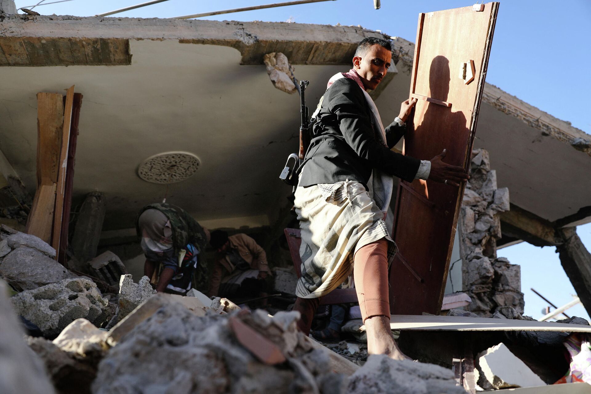 Em Saana, no Iêmen, cidadãos manipulam os destroços de um telhado de uma casa demolida por bombardeios de forças sauditas, em 18 de janeiro de 2022 - Sputnik Brasil, 1920, 10.02.2022