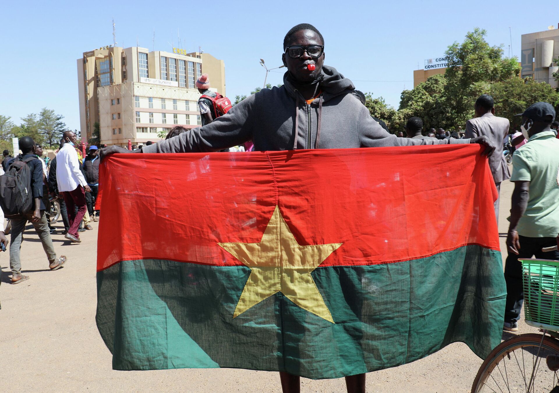 Homem mostra bandeira burquinense em apoio aos militares do país, que prenderam o presidente Marc Kaboré, em Burkina Faso, 24 de janeiro de 2022 - Sputnik Brasil, 1920, 25.01.2022