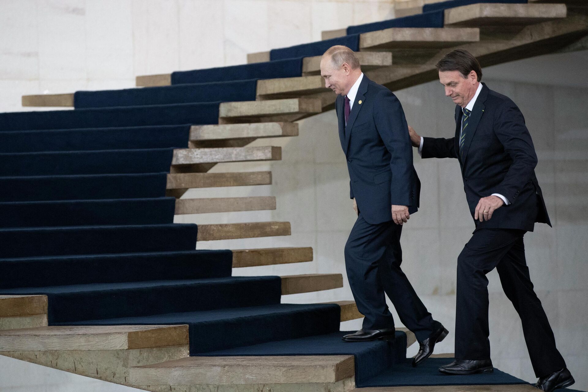 O presidente da Rússia, Vladimir Putin (E) e o presidente do Brasil, Jair Bolsonaro, caminham para participar da 11ª Cúpula do BRICS no palácio do Itamaraty em 14 de novembro de 2019 em Brasília, Brasil - Sputnik Brasil, 1920, 08.02.2022