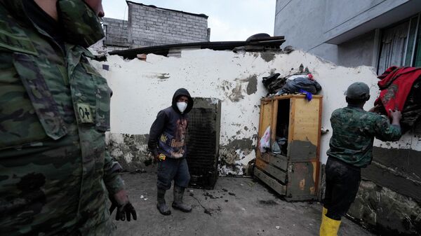 Em Quito, no Equador, um soldado conversa com civis após a recuperação de um refrigerador em meio a um deslizamento de terra após fortes chuvas na região, em 3 de fevereiro de 2022 - Sputnik Brasil