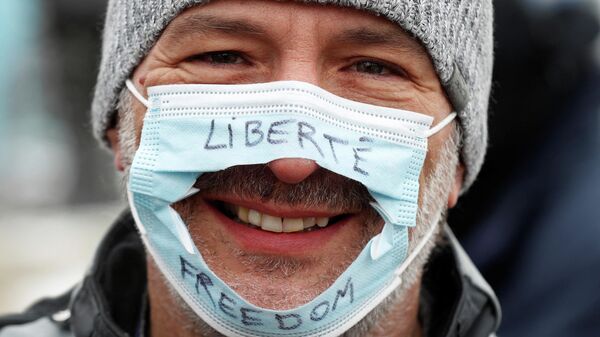 Homem usa uma máscara cirúrgica que foi cortada com as palavras Liberdade em inglês e francês, apoiando o protesto contra vacinas dos caminhoneiros, em Ottawa, Ontário, Canadá, 6 de fevereiro de 2022. - Sputnik Brasil