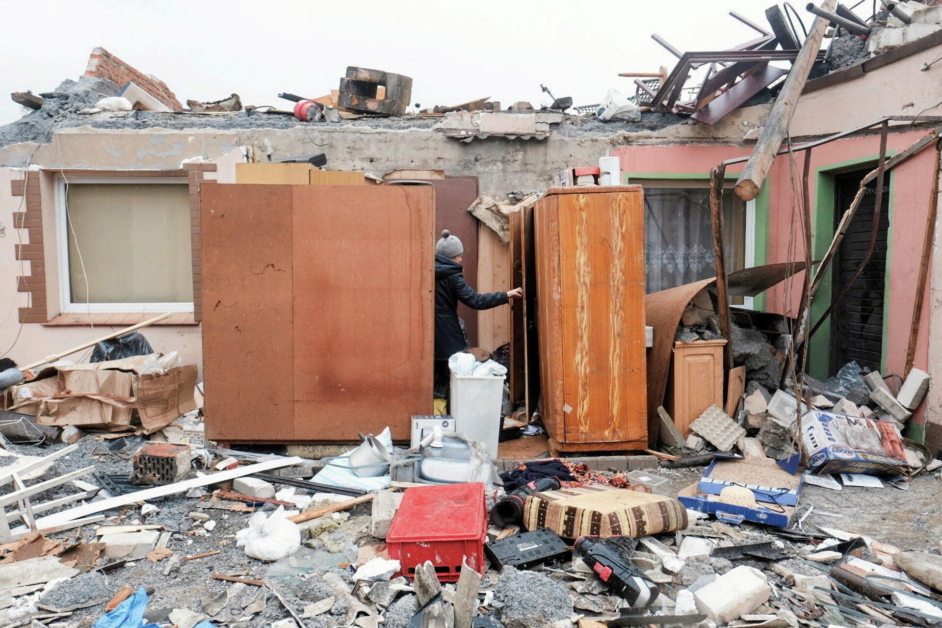 Uma mulher observa os danos de uma casa causados ​​por uma tempestade em Dobrzyca, perto de Jarocin, Polônia, em 17 de fevereiro de 2022 - Sputnik Brasil, 1920, 17.02.2022