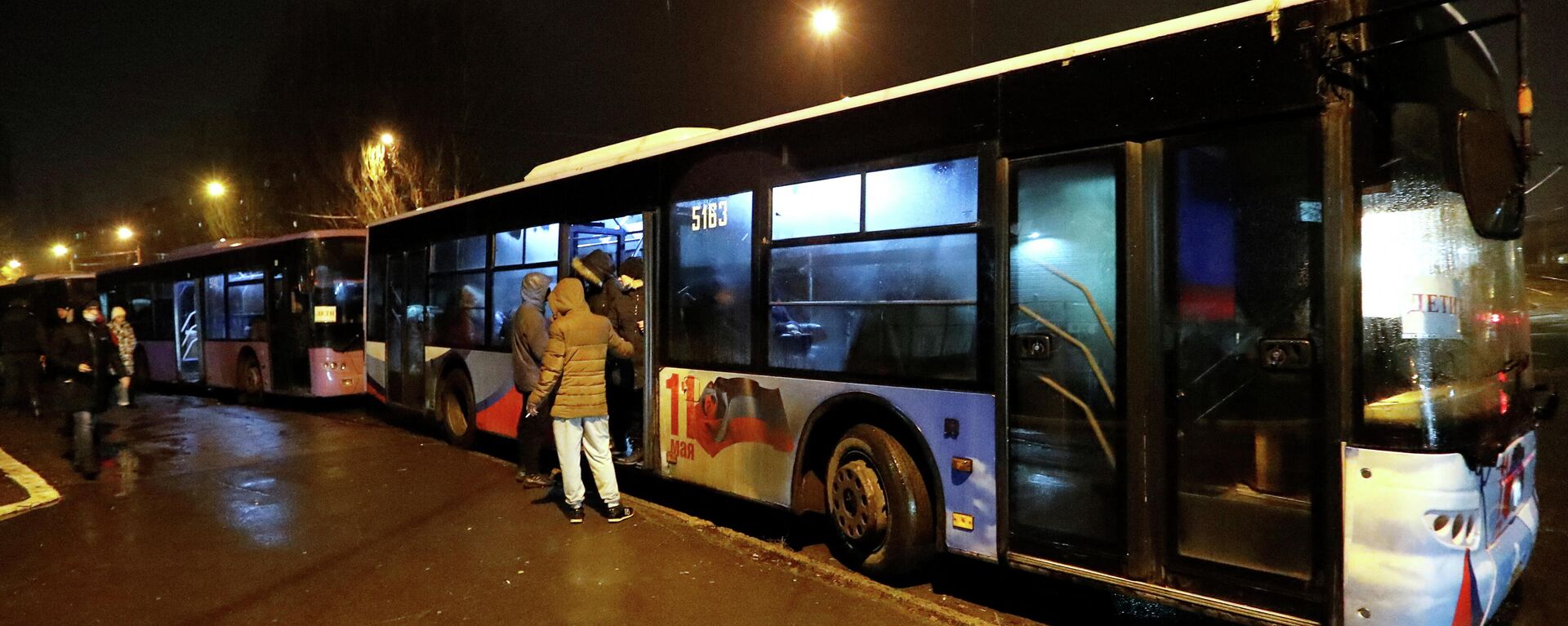 Pessoas embarcam em ônibus organizados para evacuar moradores locais, na cidade de Donetsk, Ucrânia, 18 de fevereiro de 2022 - Sputnik Brasil, 1920, 18.02.2022