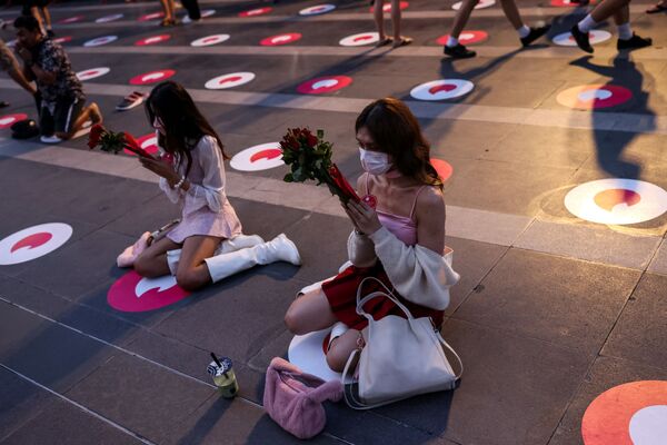 Pessoas rezam com rosas vermelhas no Santuário Trimurti, que se acredita trazer amor aos que o adoram, no Dia dos Namorados, Bangkok, Tailândia, 14 de fevereiro de 2022 - Sputnik Brasil