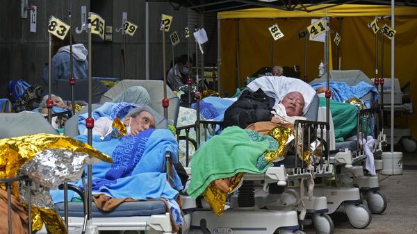 Pacientes deitados em leitos de hospital em meio à disseminação da COVID-19 fora do Centro Médico da Caritas, Hong Kong, China, 16 de fevereiro de 2022 - Sputnik Brasil
