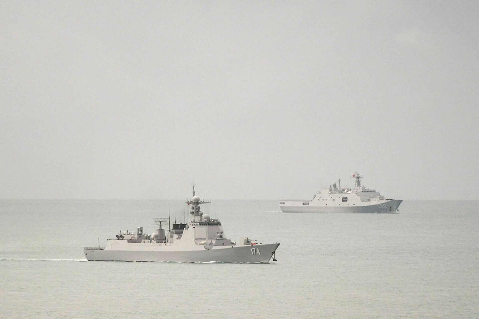 Destróier de mísseis guiados de classe Luyang da Marinha do Exército de Libertação Popular (ELP) da China (à esquerda) e navio anfíbio de transporte de classe Yuzhao da Marinha do ELP chinês deixam o estreito de Torres e entram no mar de Coral em 18 de fevereiro de 2022 - Sputnik Brasil, 1920, 20.02.2022