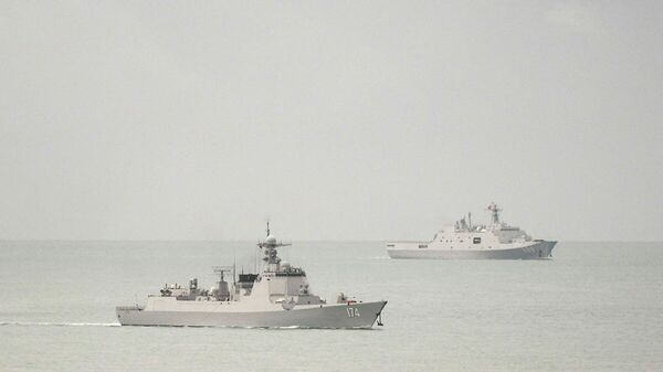 Destróier de mísseis guiados de classe Luyang da Marinha do Exército de Libertação Popular (ELP) da China (à esquerda) e navio anfíbio de transporte de classe Yuzhao da Marinha do ELP chinês deixam o estreito de Torres e entram no mar de Coral em 18 de fevereiro de 2022 - Sputnik Brasil