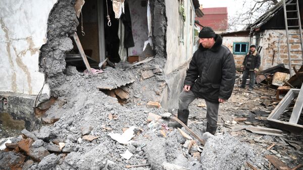Homem perto de uma casa destruída após bombardeio em Gorlovka, República Popular de Donetsk, 24 de fevereiro de 2022 - Sputnik Brasil