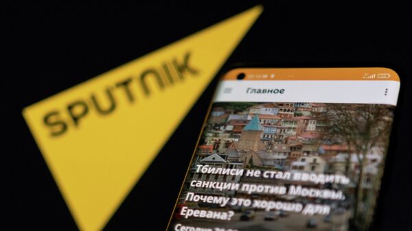 Um smartphone exibe o aplicativo da Sputnik à frente de seu logotipo, nesta ilustração de 28 de fevereiro de 2022 - Sputnik Brasil