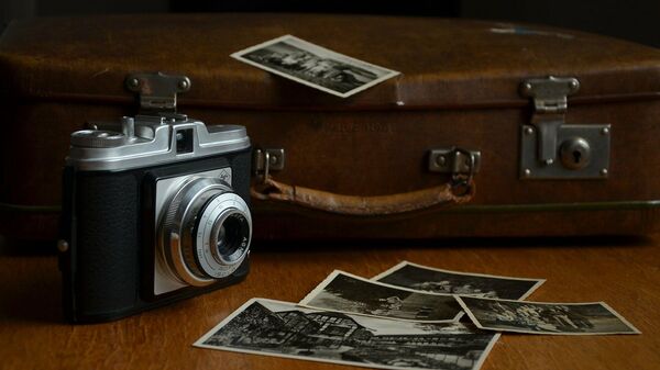 Câmera e fotos antigas dispostas na mesa (imagem de referência) - Sputnik Brasil