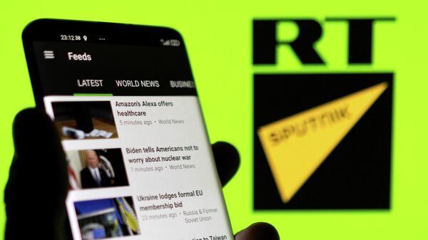 Aplicativo do RT em smartphone diante de logotipo do RT e da Sputnik em 28 de fevereiro de 2022 - Sputnik Brasil
