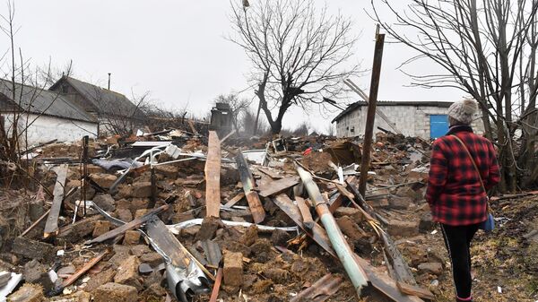 Mulher junto de casa destruída em Nikolaevka, República Popular de Donetsk - Sputnik Brasil