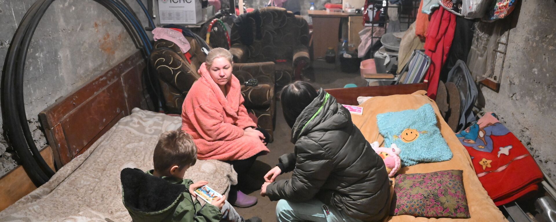 Mulher se esconde com crianças em porão de uma casa dos disparos das Forças Armadas da Ucrânia em Gorlovka - Sputnik Brasil, 1920, 20.09.2025