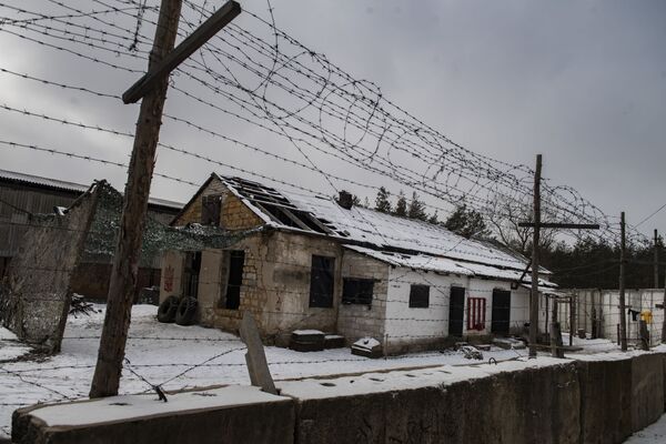 Arame farpado em torno da área de antiga fábrica de salsichas em que existia prisão ilegal do batalhão nacionalista Aidar para pró-independentistas locais e simpatizantes suspeitos, mostrando seu interior, em Polovinkino, região de Starobelsk, República Popular de Lugansk - Sputnik Brasil