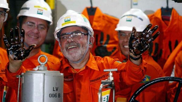 O presidente Luiz Inácio Lula da Silva mostra as mãos sujas de petróleo cru depois de acionar uma das válvulas de controle dos poços do navio-plataforma P 50 da Petrobras, que deu início à produção do campo de Albacora Leste na Bacia de Campos, litoral do estado do Rio de Janeiro (foto de arquivo) - Sputnik Brasil