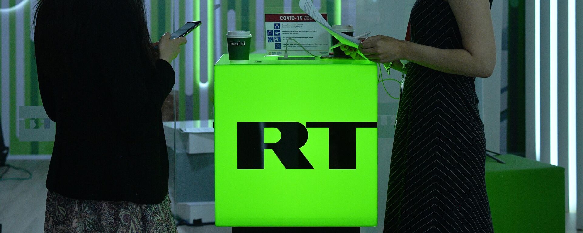 Em São Petersburgo, na Rússia, duas mulheres aparecem paradas em um estande da RT durante um evento internacional, 3 de junho de 2021. - Sputnik Brasil, 1920, 16.03.2022