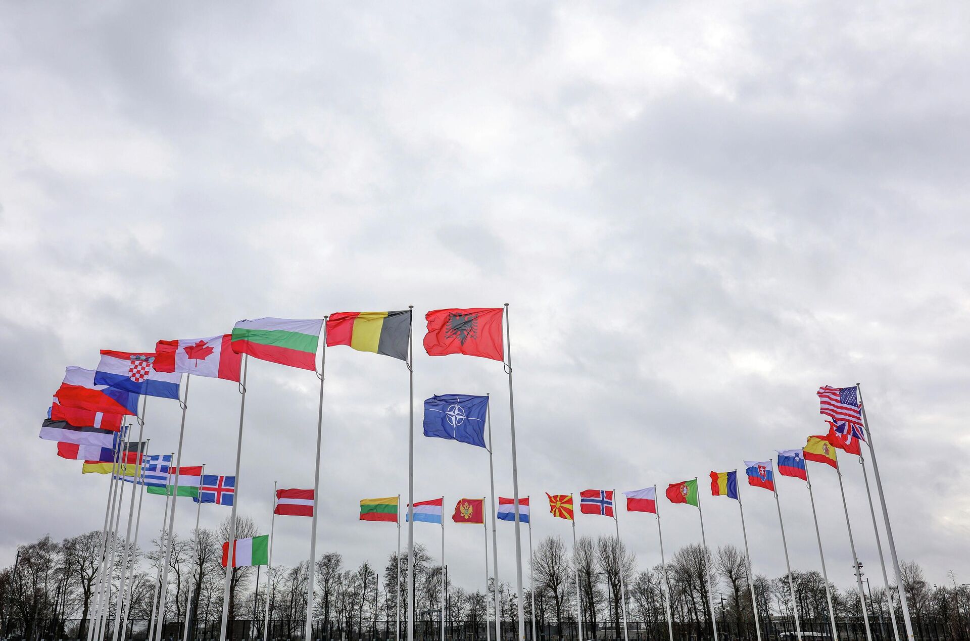 Bandeiras dos países-membros da Organização do Tratado do Atlântico Norte (OTAN) tremulam ao vento do lado de fora da sede da aliança em Bruxelas, 22 de fevereiro de 2022 - Sputnik Brasil, 1920, 11.05.2022